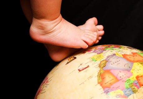 baby standing on a globe