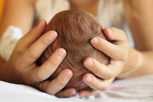 woman holding newborn baby's head