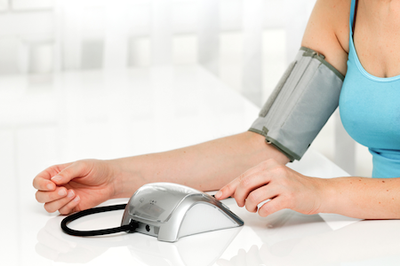 pregnant woman taking blood pressure using a machine