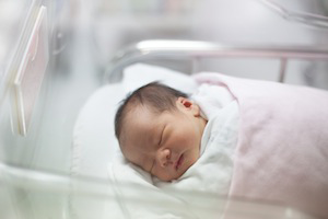 newborn baby lying in a hospital crib