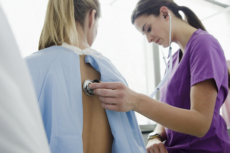 Nurse using a stethoscope on a woman's back